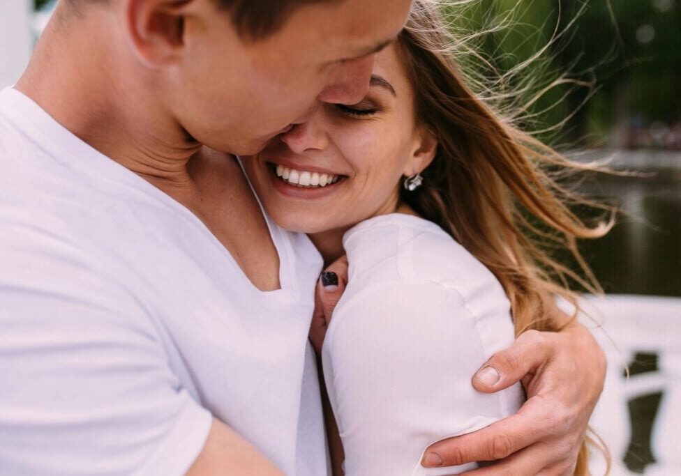 closeup shot of a couple hugging and smiling